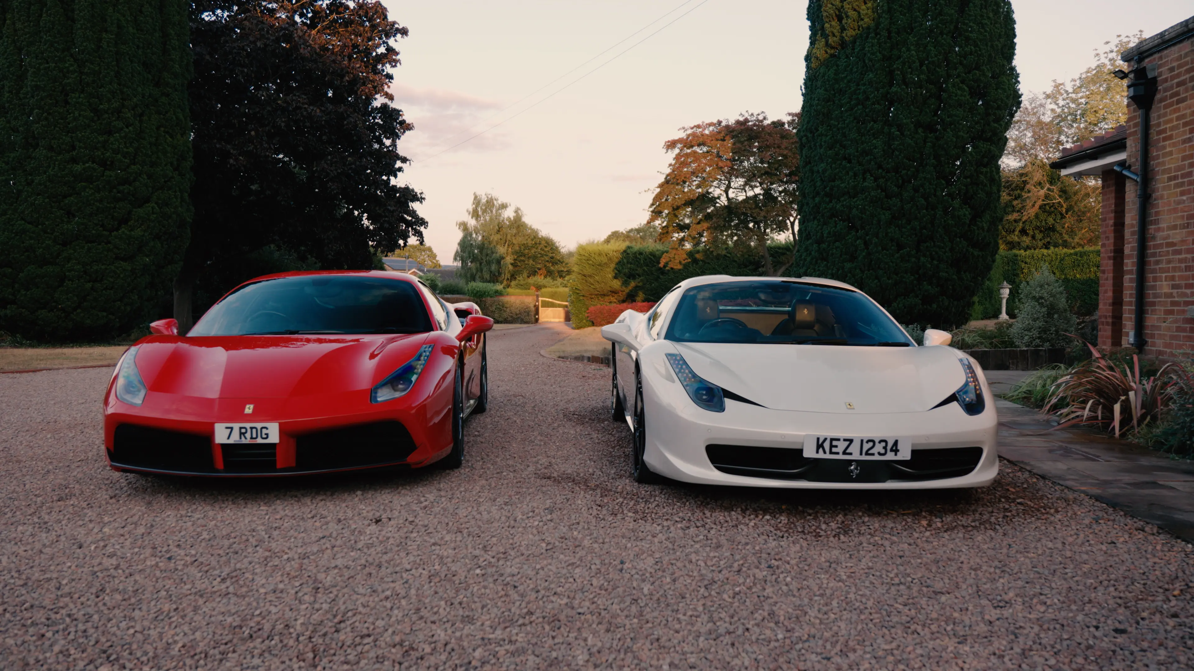 Red and white Ferraris parked on a gravel driveway after detailing