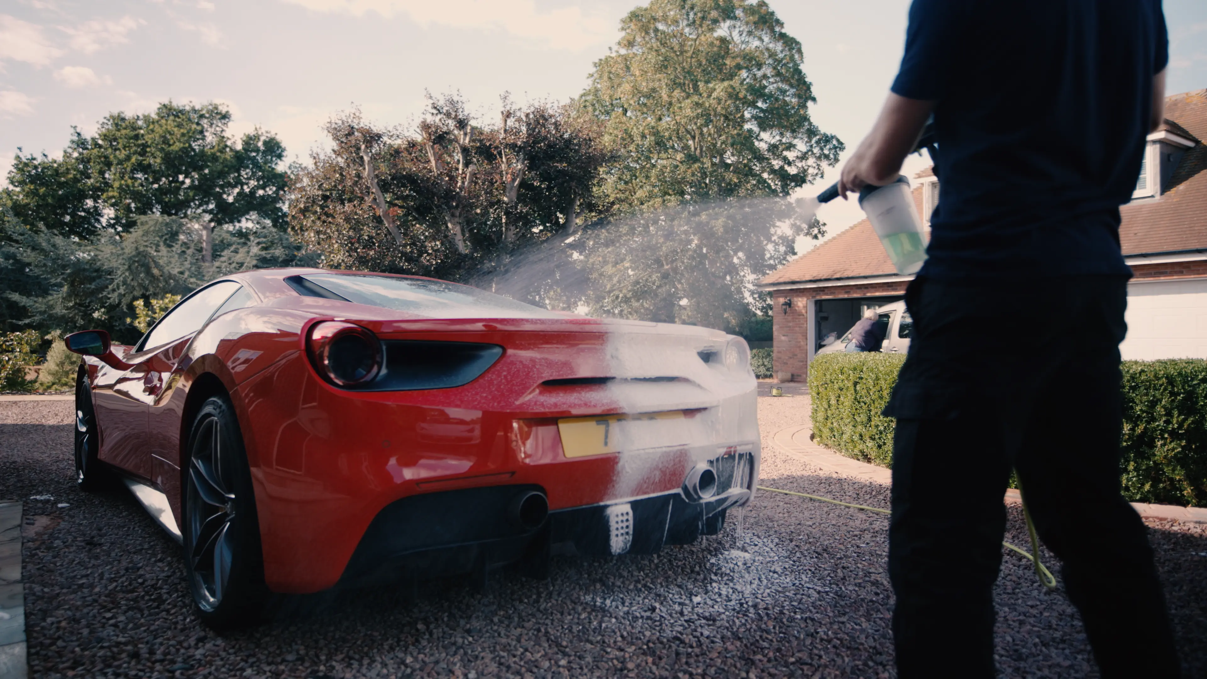 Red Ferrari covered in snow foam during exterior detailing